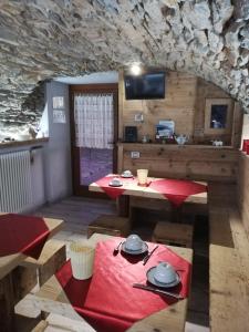ein Esszimmer mit einem Tisch und Stühlen sowie einem TV in der Unterkunft Il Teggiolo in Varzo