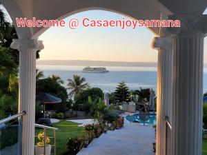 a view from the balcony of a resort with a cruise ship in the ocean at casaenjoysamana in Los Naranjos
