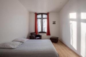 a bedroom with a bed and a window with red curtains at L'escapade Dieppoise - 3 chambres, 1er étage in Dieppe