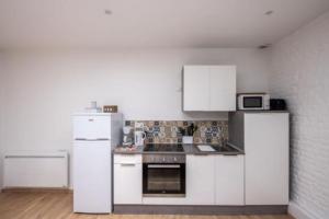 a kitchen with white cabinets and a white refrigerator at L'escapade Dieppoise - 3 chambres, 1er étage in Dieppe