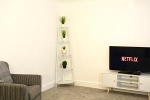 a living room with a tv and a couch at The Duffryn in Mountain Ash