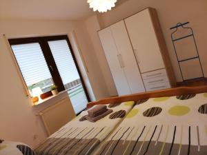 een slaapkamer met een bed en 2 ramen bij Ebenerdige Ferienwohnung mit großer Terrasse in der Nähe des Waldes, zum wohlfühlen in Schoneck
