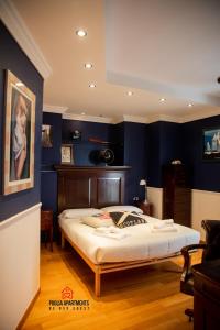1 dormitorio con 1 cama grande y paredes azules en Gateway AIRPORT Bari ELEGANT FLAT with car park en Bari