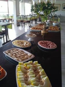 a table with many plates of food on it at Hotel Escarpas do Lago Capitolio in Capitólio