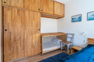 a bedroom with a crib and a wooden wall at Veermansplaat 25 - Noordzeepark Ouddorp NOT FOR COMPANIES!! in Ouddorp