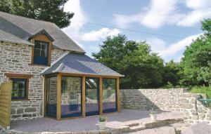a stone house with a conservatory in front of it at Stunning Home In Bréhand With Wifi in Moncontour +10 photos