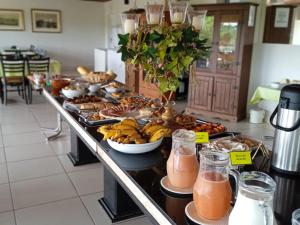 una línea de buffet con plátanos y otros alimentos y bebidas en Hotel Escarpas do Lago Capitolio, en Capitólio