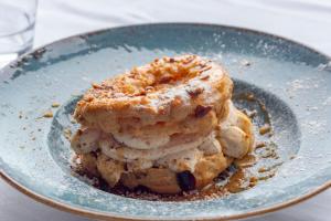 a plate with a stack of biscuits and a donut at Hotel Le Rayon Vert in Étretat