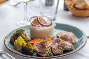 a plate of food with rice and meat and vegetables at Hotel Le Rayon Vert in Étretat