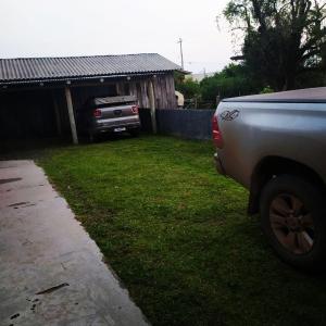 a car parked in a yard next to a house at Casa Grey in Cambara do Sul