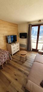 a living room with a couch and a tv at studio de charme au Melezet, les Orres. Plein Sud. in Les Orres