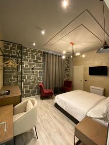 a bedroom with a white bed and a brick wall at Ardenica Boutique Hotel in Lushnjë