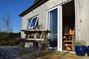 a picnic table on a deck next to a building at Tigh Eilidh (The Cabin on the Hill) in Breakish