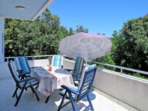 een tafel en stoelen met een parasol op een balkon bij Holiday Home Vista by Interhome in Labin