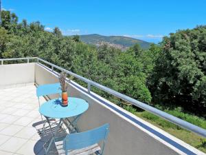 a table and two chairs on a balcony with trees at Holiday Home Vista - LBN 403 by Interhome in Labin