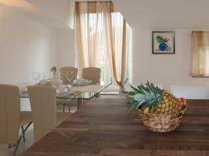 a dining room with a table and a basket of pineapple at Apartment Marinella - LBN120 by Interhome in Labin