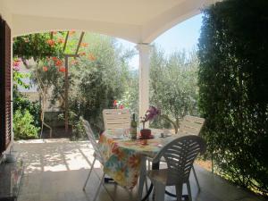 einen Tisch und Stühle auf einer Terrasse mit Tisch und Stühlen in der Unterkunft Apartment Violetta - LBN201 by Interhome in Labin