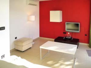 salon z czerwoną ścianą i telewizorem w obiekcie Apartment Milevoj - RAC157 by Interhome w Rabacu