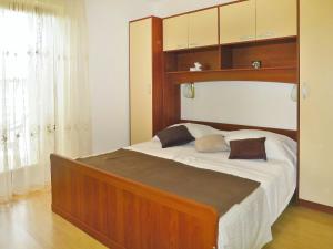 a bedroom with a large bed with a wooden headboard at Apartment Danica by Interhome in Rabac