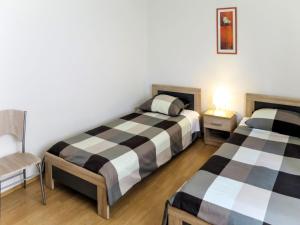 a bedroom with two beds and a chair in it at Apartment Danica by Interhome in Rabac +12 photos