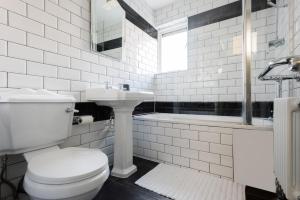 a white bathroom with a toilet and a sink at Second Nest Hampton Street in London
