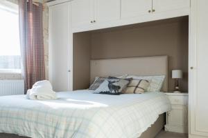 a bedroom with a bed with a white headboard at Second Nest Hampton Street in London