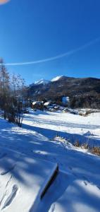 a snow covered field with mountains in the background at studio de charme au Melezet, les Orres. Plein Sud. in Les Orres