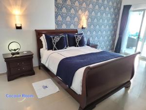 a bedroom with a bed with a blue and white comforter at casaenjoysamana in Los Naranjos