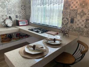 a kitchen with a counter with plates and a stove at Solar das Aroeiras in Serra do Cipo
