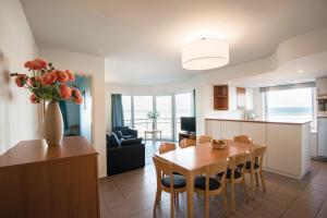 a kitchen and dining room with a table and a vase of flowers at Vayamundo Oostende - Apartments in Ostend