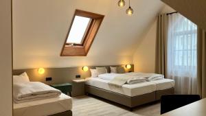 a bedroom with two beds and a window with a skylight at Hotel Waldhorn in Stuttgart