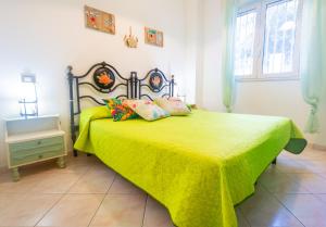 a bedroom with a green bed with pillows on it at Nido Lungomare, e sei in spiaggia... in Cala Gonone