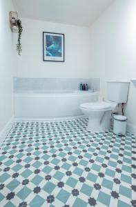 a bathroom with a white tub and a blue and white floor at Ness Central in Inverness