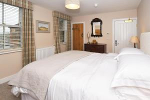 a bedroom with a large white bed and a mirror at The Royal Oak in Biddulph