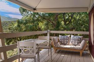 un patio con mesa y sillas en una terraza en Be Vedetta - Relais & Glamping - Adult Only, en Scarlino