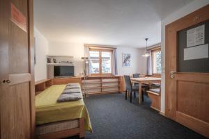 um quarto com uma cama e uma mesa de jantar em Chalet Höckli Wohnung 2. em Arosa