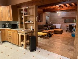 a kitchen and living room with a couch and a table at Habitation en bois authentique in Venizy +22 photos