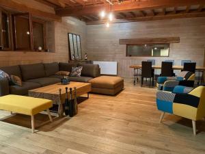 Habitation en bois authentique في Venizy: غرفة معيشة مع أريكة وطاولة