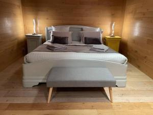a bedroom with a large white bed and two candles at Habitation en bois authentique in Venizy