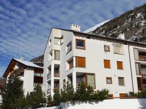 ein weißes Gebäude mit einem Berg im Hintergrund in der Unterkunft Apartment Chesa Piz Cotschen 2 by Interhome in Pontresina