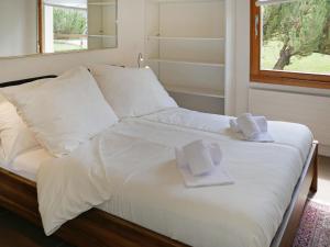 a bed with white pillows and towels on it at Apartment Chesa Piz Cotschen 2 by Interhome in Pontresina