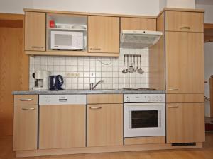a kitchen with wooden cabinets and a white microwave at Apartment Handle-2 by Interhome in Ried im Oberinntal