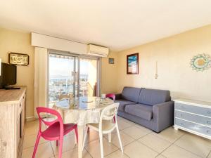 ein Wohnzimmer mit einem Tisch und einem Sofa in der Unterkunft Apartment Le Capitole-2 by Interhome in Fréjus