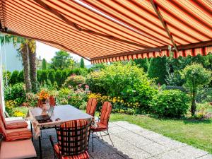 patio con tavolo e sedie sotto ombrellone di Holiday Home Ar Ronchée N- 9 by Interhome ad Astano
