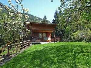 uma cabana na floresta com um relvado verde em Chalet Pierre Blanche by Interhome em Servoz