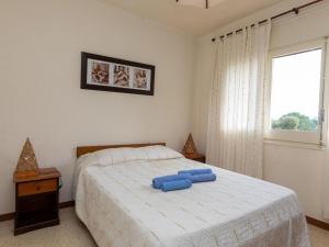 Un dormitorio con una cama con una almohada azul. en Apartment Sarnella by Interhome, en Llançà