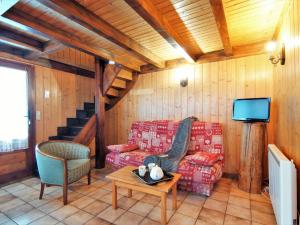 uma sala de estar com um sofá e uma televisão em Chalet Pierre Blanche by Interhome em Servoz