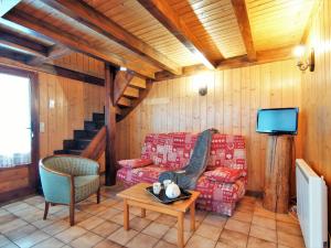 a living room with a couch and a tv at Chalet Pierre Blanche by Interhome in Servoz