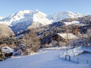 een met sneeuw bedekte berg met een huis op de voorgrond bij Chalet L'Epachat by Interhome in Mémontel