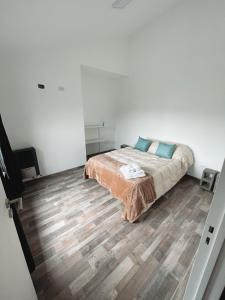 1 dormitorio con 1 cama y suelo de madera en Bella Vista 2! en Esquel